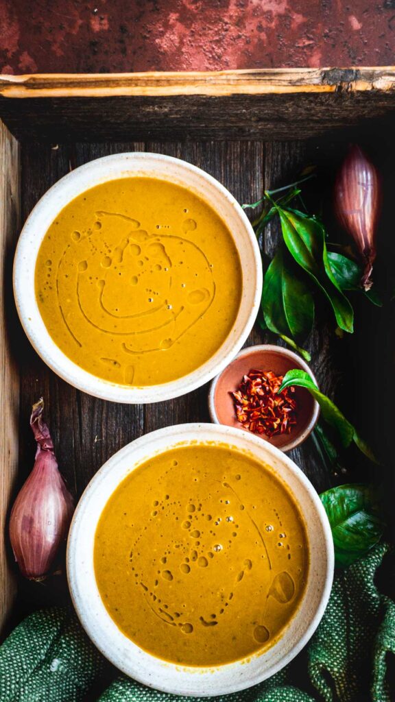 This is a picture of two moringa/malunggay/ murungai keerai soup bowls in a rustic serving tray.