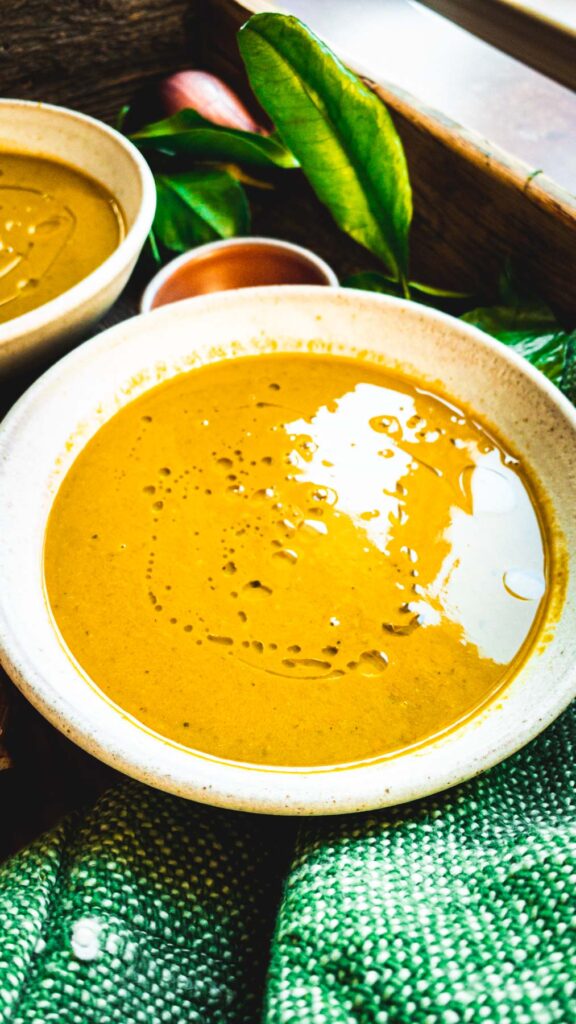 This is a bowl of Murungai Keerai Soup | Moringa leaves soup | Drumstick leaves soup served on a bowl.