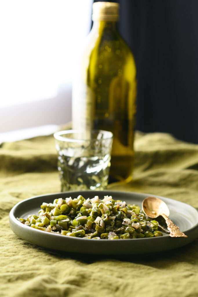 This is a picture of green beans poriyal on a plate with a spoon.