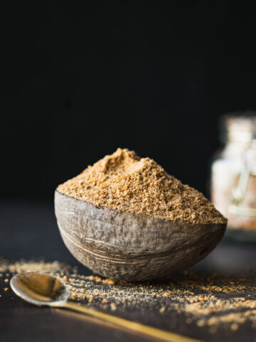 This is a hero shot of the Idli milagai podi in a rustic bowl on a rustic table