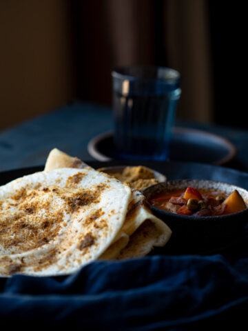 This is a picture of podi dosa (gun powder dosa) served on a plate.