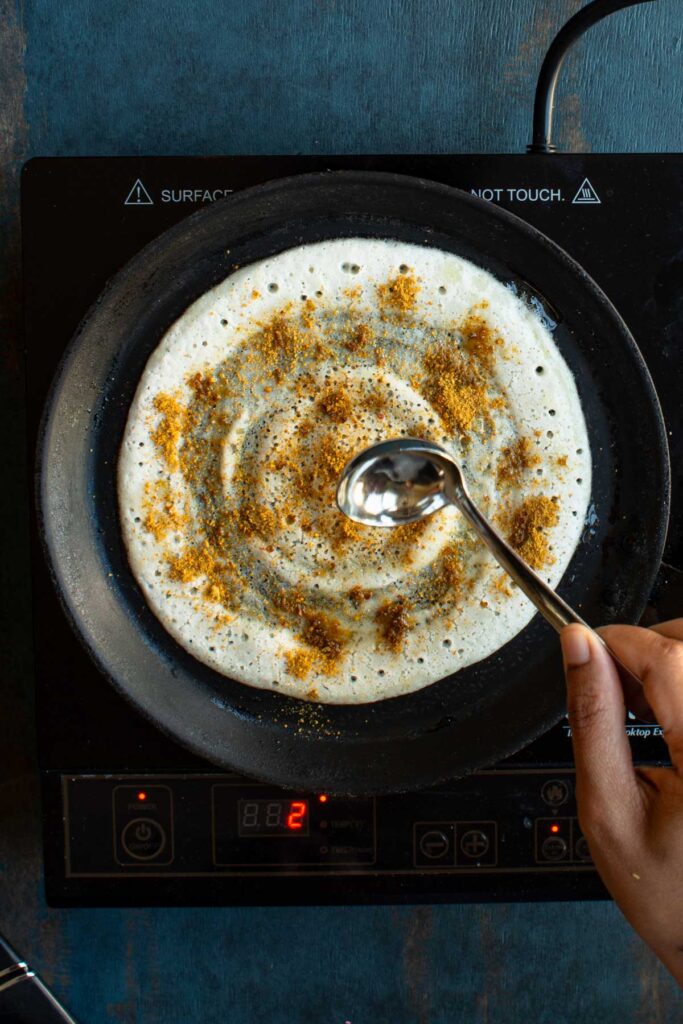 spread ghee on the dosa podi and gun powder dosa and cook till crisp.