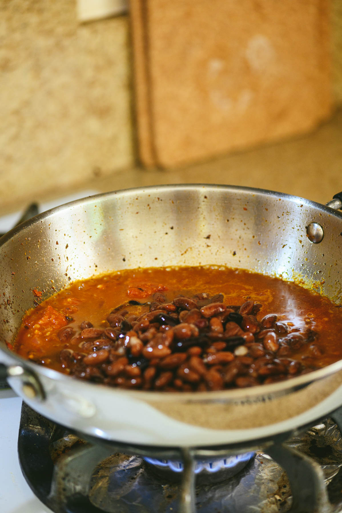 Add masala powders to the cooked tomatoes to make rajma.