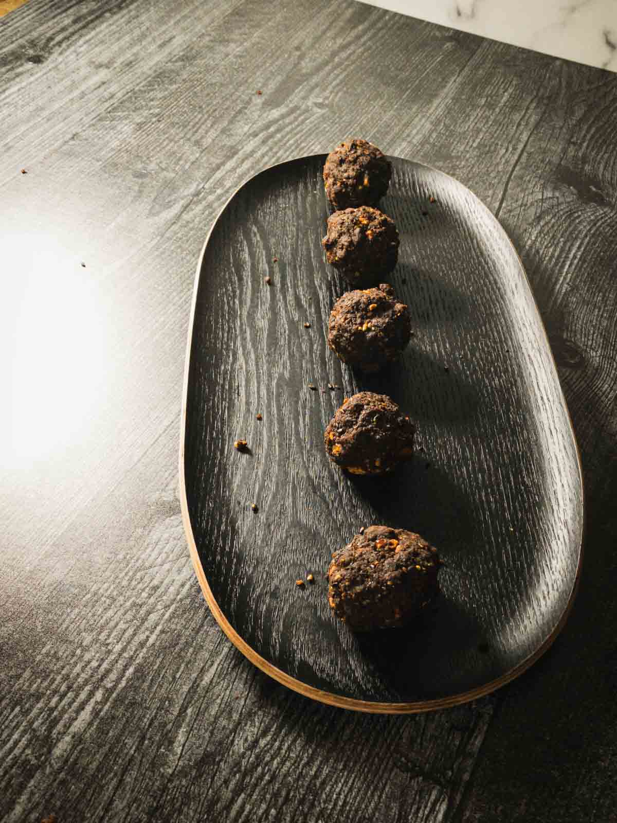 healthy ragi laddu served in a plate in a single vertical line.