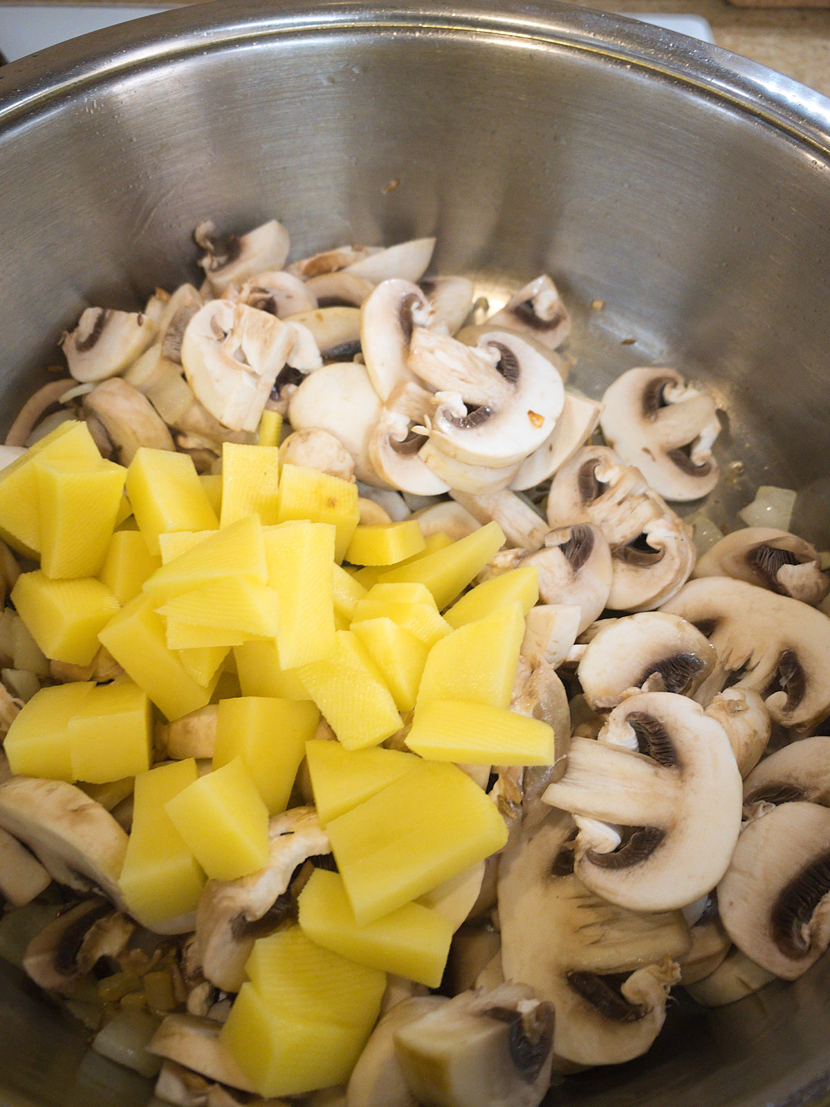 Sauteing mushroom and potato for making mushroom soup.