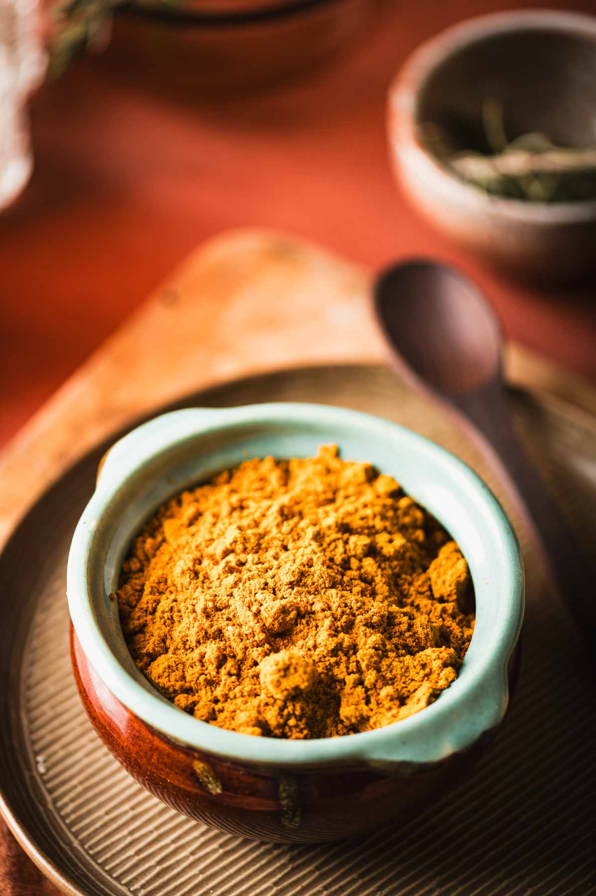 This is an image of chicken curry masala powder in a ceramic storage dish.