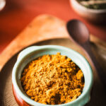 This is an image of chicken curry masala powder in a ceramic storage dish.