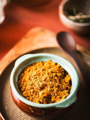 This is an image of chicken curry masala powder in a ceramic storage dish.