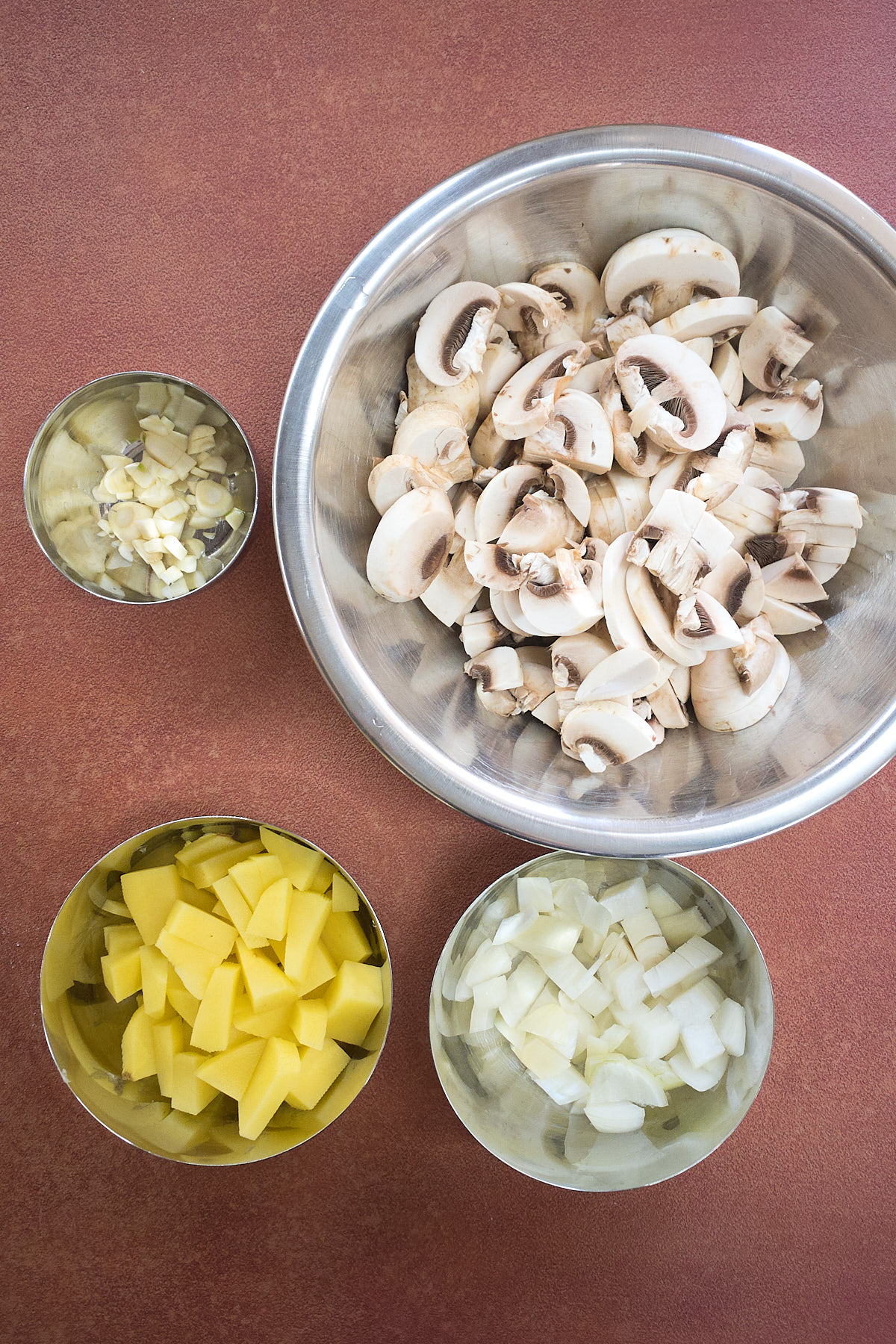 The ingredients like mushroom, potato, onion are prepped and kept in a bowl.