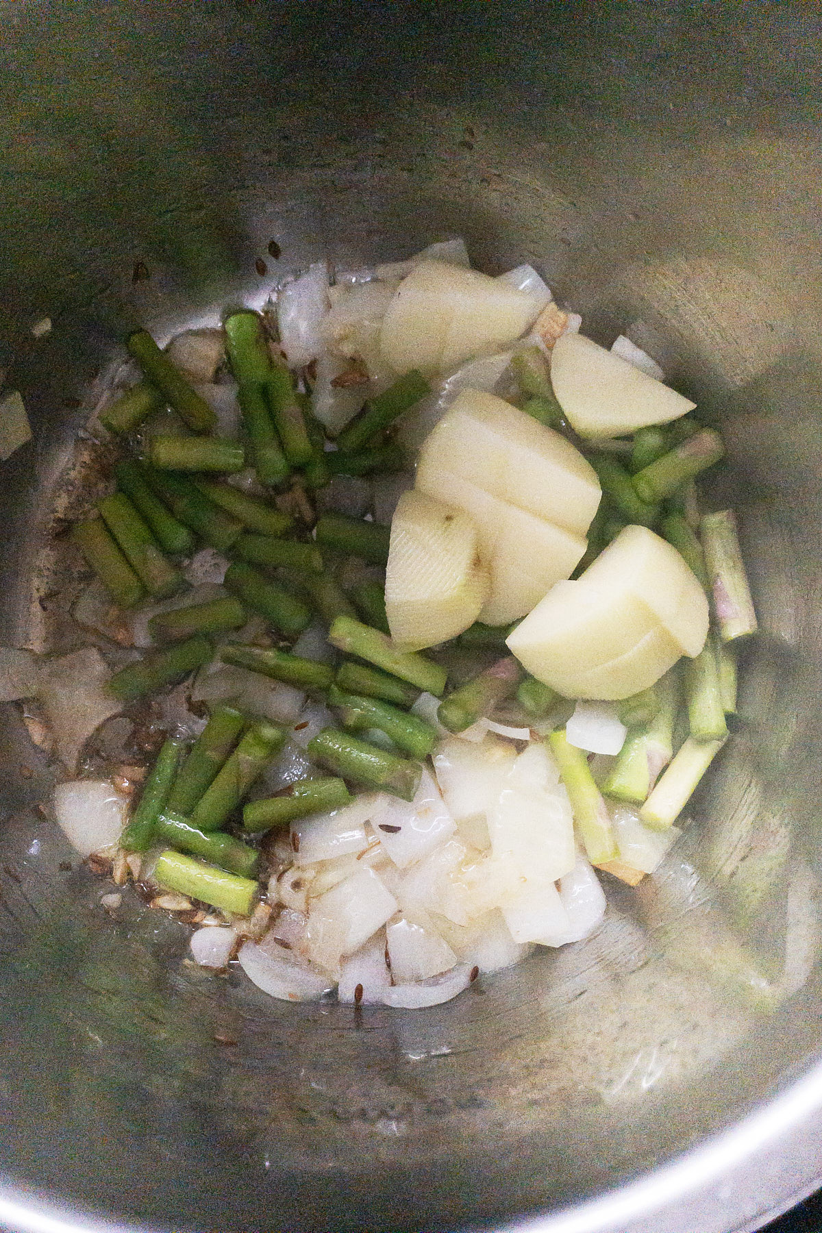 Sauteing potatoes and asparagus for almond broccoli asparagus soup.