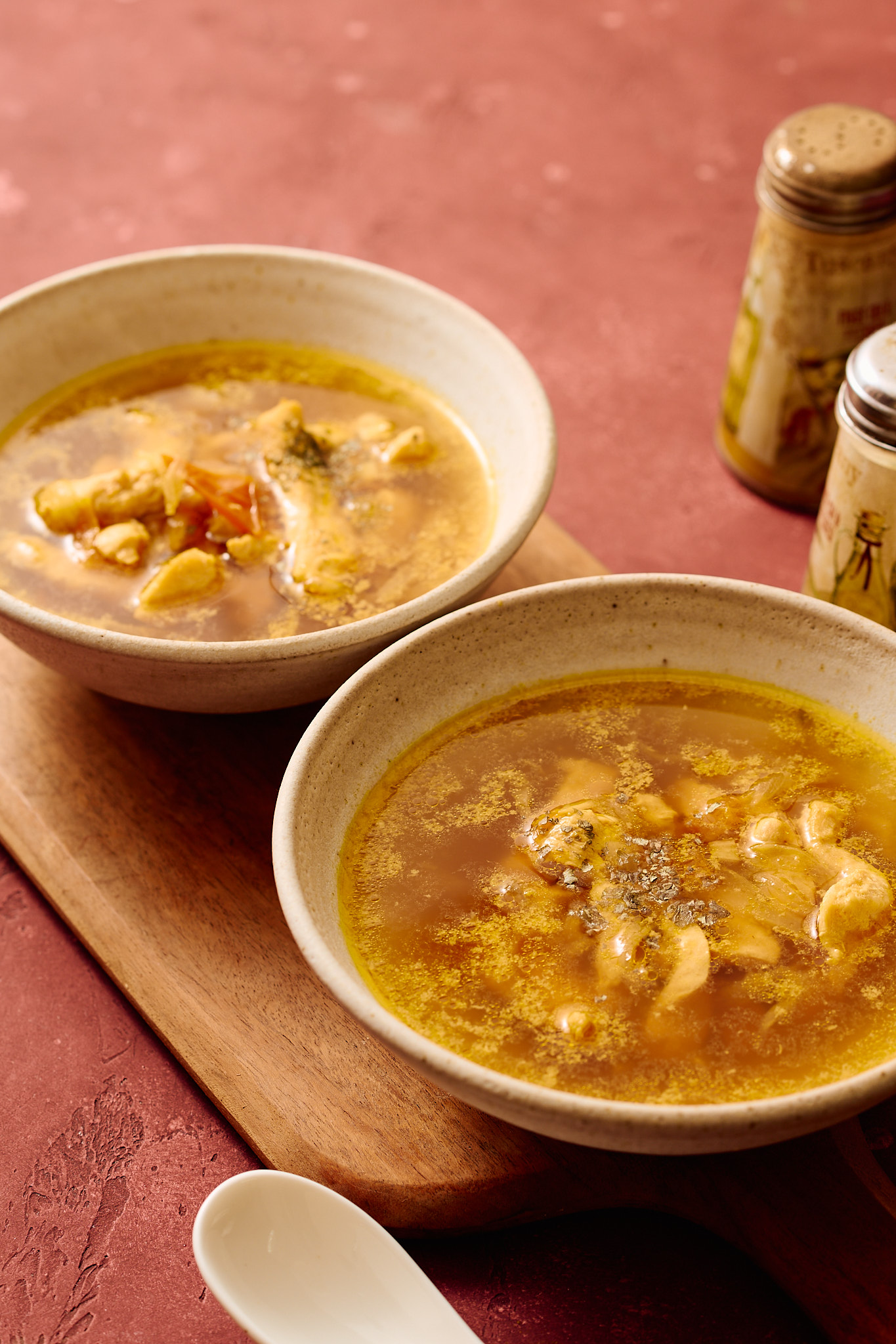 Instant Pot Indian chicken soup served in ceramic bowls, light golden broth with tender chicken, photographed in a warm, rustic setting.