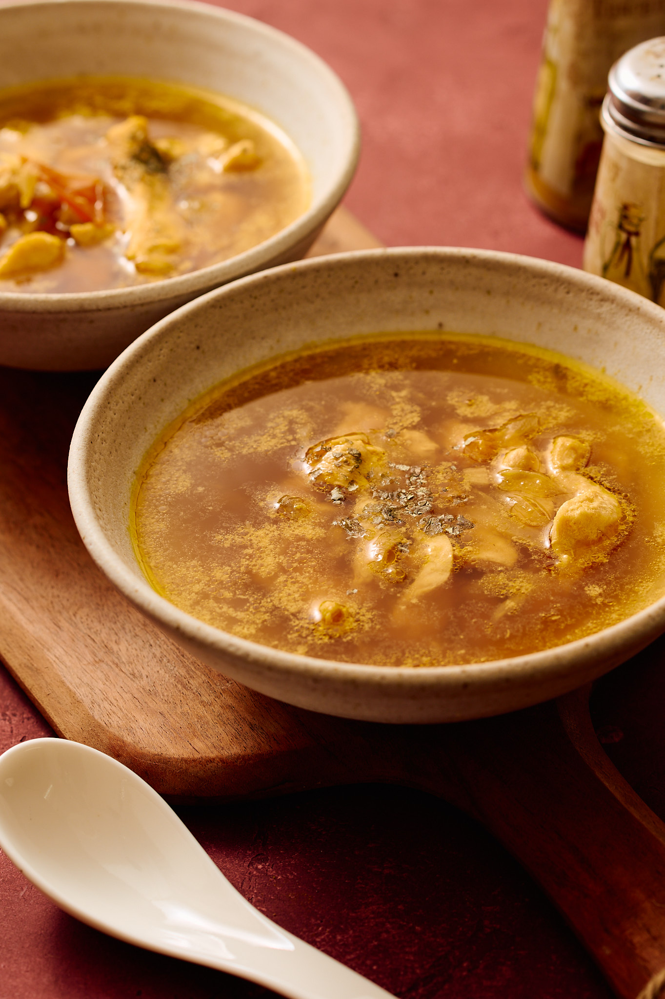 Instant Pot Indian chicken soup served in ceramic bowls, light golden broth with tender chicken, photographed in a warm, rustic setting.