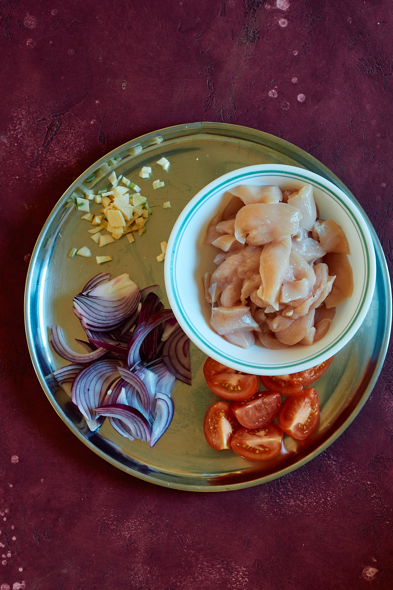 This is a picture of the prepped ingredients for the indian chicken soup on a plate on a table.