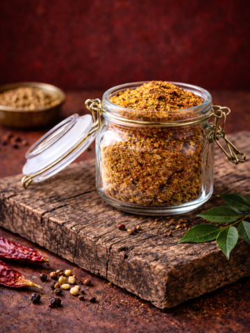 Glass jar filled with sundal powder placed on a wooden board